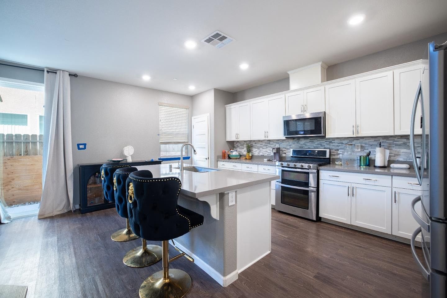 Quartz island and white kitchen cabinetry at 10707 Piave Way, Stockton